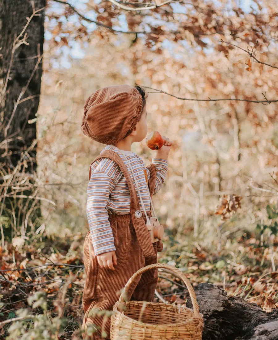 Un parent et son enfant partagent un moment complice dans une lumière douce